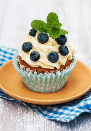 Cupcake with fresh blueberries on a old wooden tableの写真素材