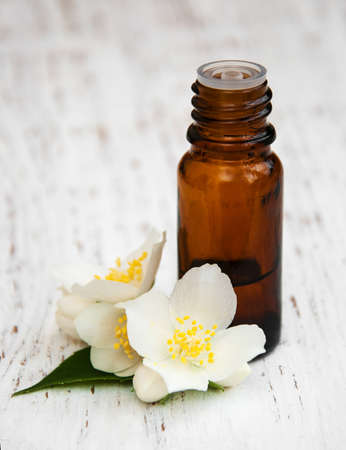 Massage oil with jasmine flowers on a wooden backgroundの写真素材