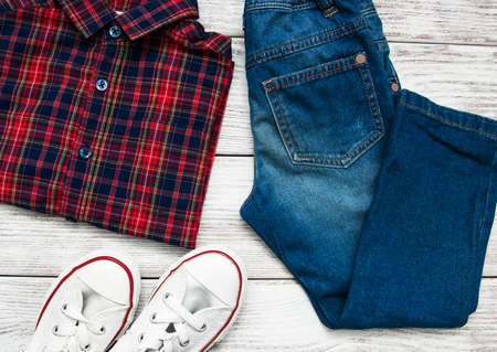 Checkered shirt and jeans on a old wooden tableの写真素材