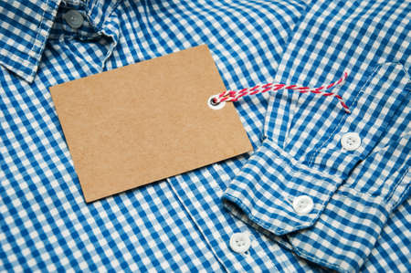 Checkered shirt on a table with tagの写真素材