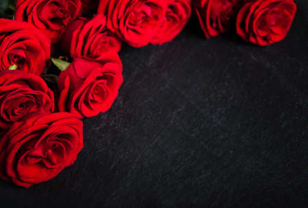 Red roses on a black stone  background