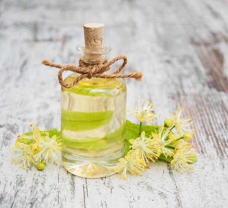 bottle of essential linden oil and yellow lime flowersの写真素材