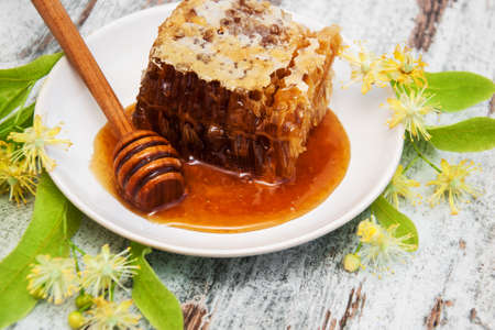 Honey  and linden flowers on a boardの写真素材