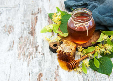 Honey  and linden flowers on a boardの写真素材