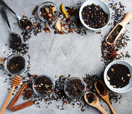 Aromatic dry tea in bowls on a gray stone backgroundの写真素材