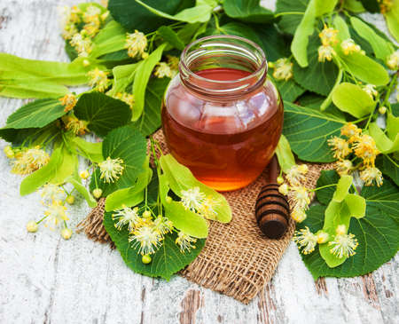 Honey  and linden flowers on a boardの写真素材