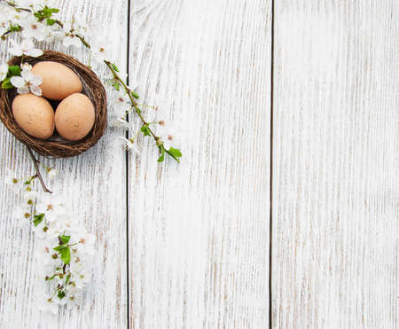 Easter eggs and spring  blossom on a old wooden backgroundの写真素材