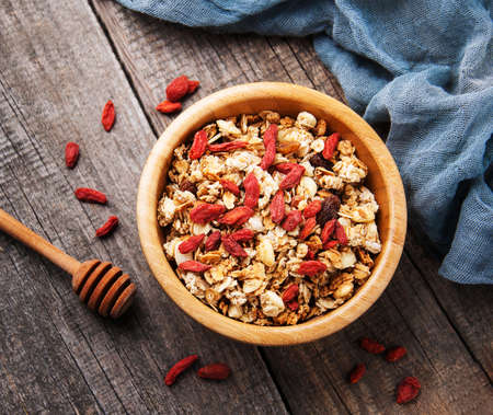 Muesli with goji berries in a bowl on a wooden backgroundの写真素材