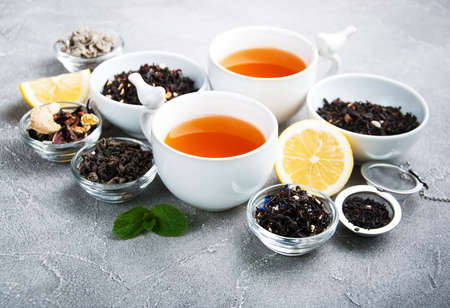 Cups of tea with aromatic dry tea in bowls on a gray stone backgroundの写真素材