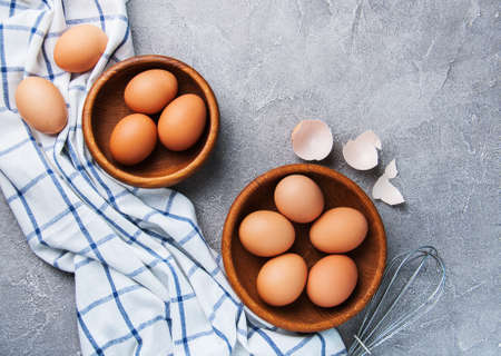 Eggs and wooden bowls with eggs on the tableの写真素材