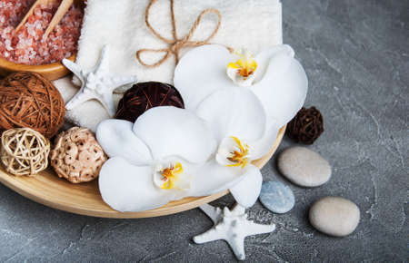 Spa products with white orchids on a gray stone backgroundの写真素材