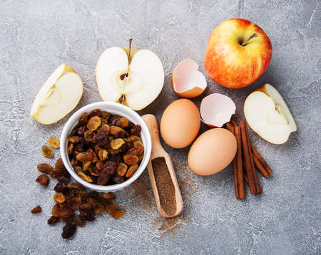 Baking ingredients - eggs, spice, apples, raisins, cinnamon sticks