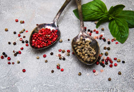 Spoons with red and green peppers on a stone backgroundの写真素材