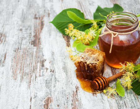 Honey  and linden flowers on a boardの写真素材