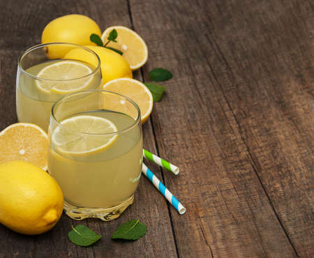 Glasses of lemon juice on a old wooden tableの写真素材