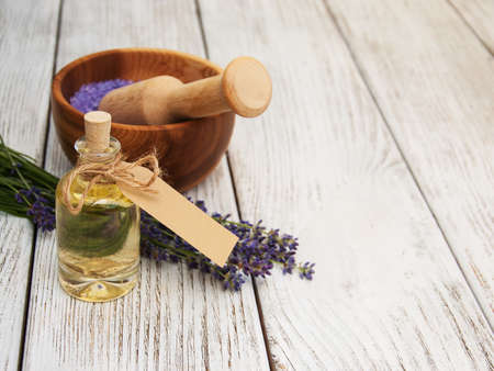 lavender oil with bath salt and fresh lavender on a old wooden backgroundの写真素材