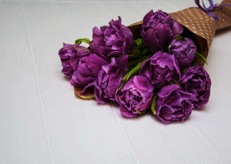 Spring tulip flowers on a white wooden tableの写真素材