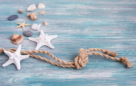Seashells and sea decorations with rope on a wooden backgroundの写真素材