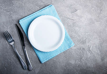 Empty white plate with nupkin on a gray stone backgroundの写真素材