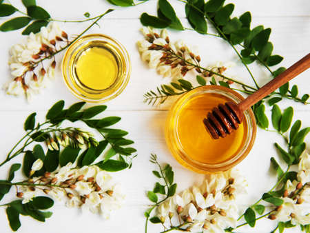 Honey with acacia blossoms on a wooden backgroundの写真素材