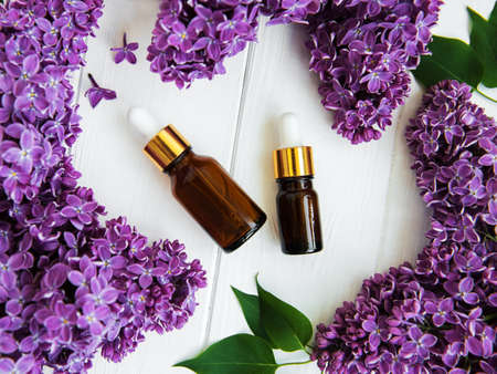 Essential oil with lilac flowers on a old wooden backgroundの写真素材
