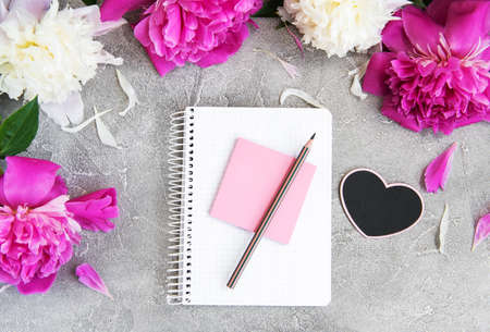  note book with peonies on a old stone background