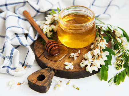 Honey with acacia blossoms on a wooden backgroundの写真素材