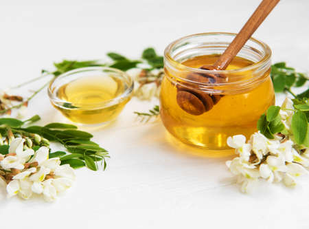 Honey with acacia blossoms on a wooden backgroundの写真素材