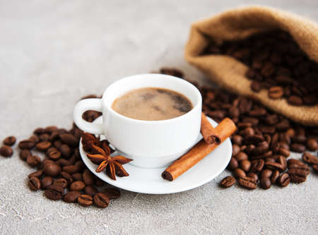Cup of coffee with roasted beans on table