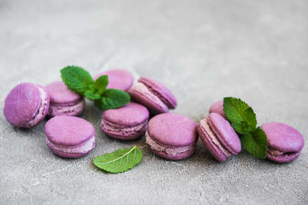 french dessert,  sweet purple macaroons with mint on a stone backgroundの写真素材