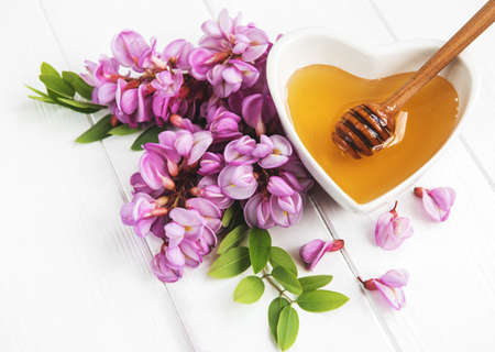Honey with acacia blossoms on a wooden backgroundの写真素材