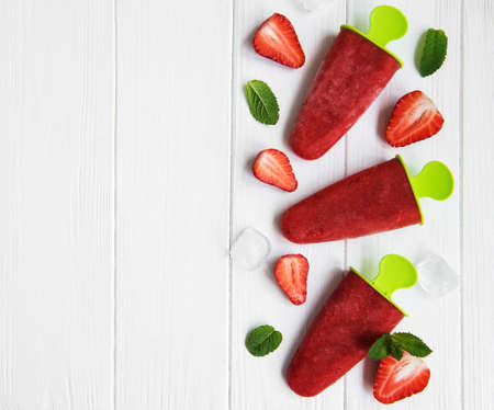 homemade strawberry ice cream and fresh strawberries on a tableの写真素材