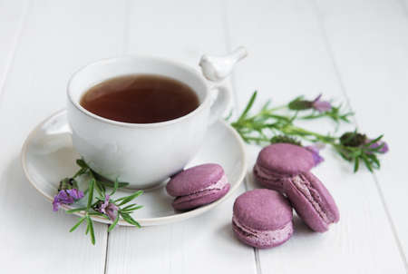 Cup of tea and macarons with fresh lavender on a tableの写真素材