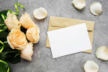 Yellow roses and greeting card on a stone backgroundの写真素材