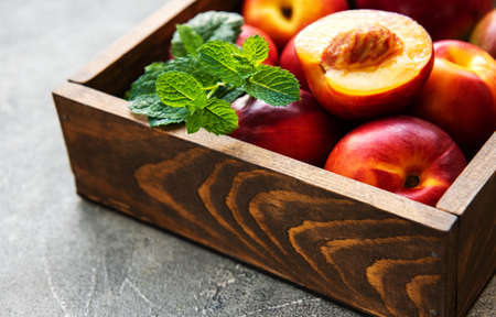 Box with fresh nectarines on a stone backgroundの写真素材