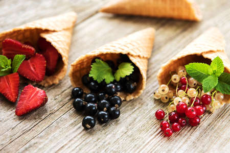ice cream cones with berries on a wooden backgroundの写真素材