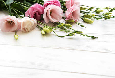 Fresh pink eustoma flowers frame on wooden backgroundの写真素材