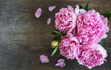 Pink peony flowers on a old  wooden tableの写真素材