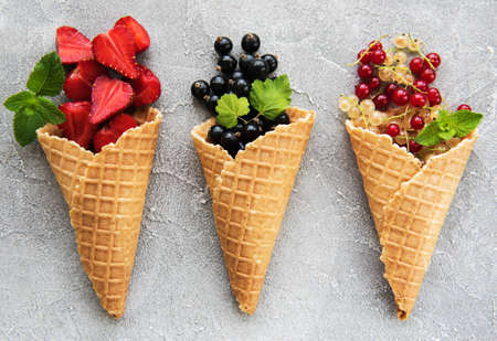 ice cream cones with berries on a stone background