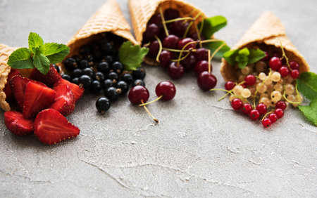 Ice cream cones with berries on a stone backgroundの写真素材
