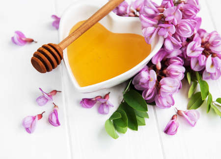 Honey with acacia blossoms on a wooden backgroundの写真素材