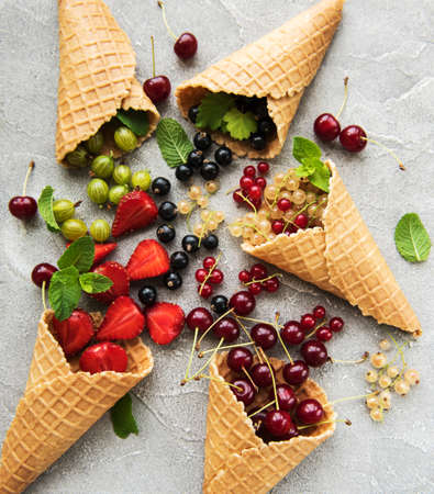 ice cream cone with berries on a stone background