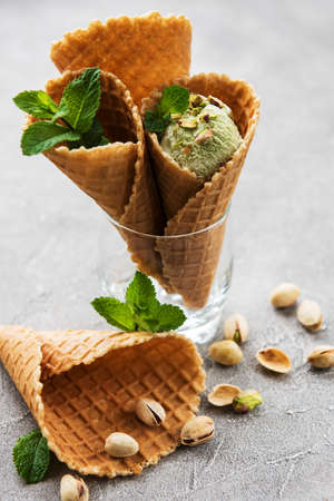 Pistachio ice cream and mint with pistachio nuts on a stone background