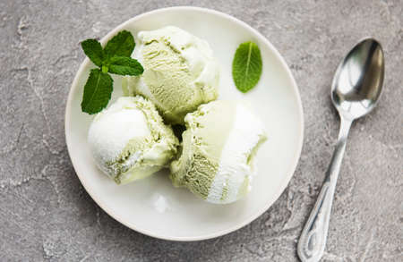 pistachio ice cream and mint with pistachio nuts on a stone backgroundの写真素材