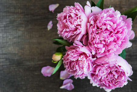 Pink peony flowers on a old  wooden tableの写真素材