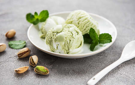 pistachio ice cream and mint with pistachio nuts on a stone backgroundの写真素材