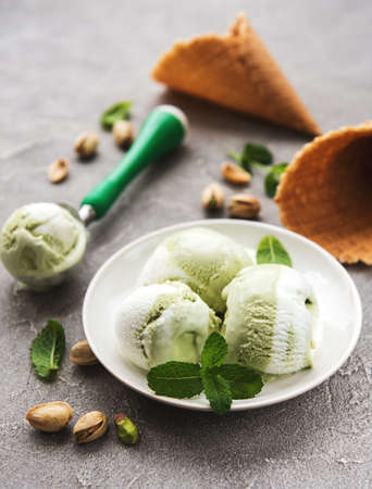 pistachio ice cream and mint with pistachio nuts on a stone backgroundの写真素材