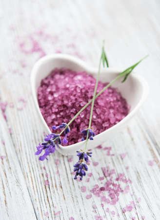 Heart-shaped bowl with sea salt  and fresh lavender flowers on a old wooden tableの写真素材