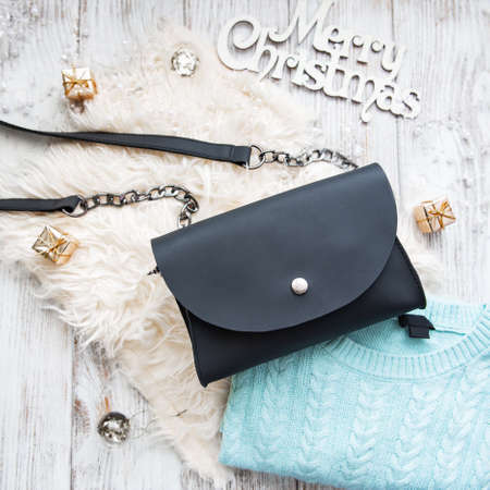 Black leather bag with Christmas decorations - flat lay