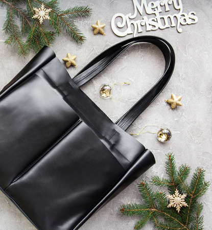Black leather bag with Christmas decorations - flat layの写真素材